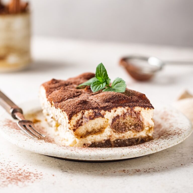 Piece of traditional Italian dessert tiramisu on white background