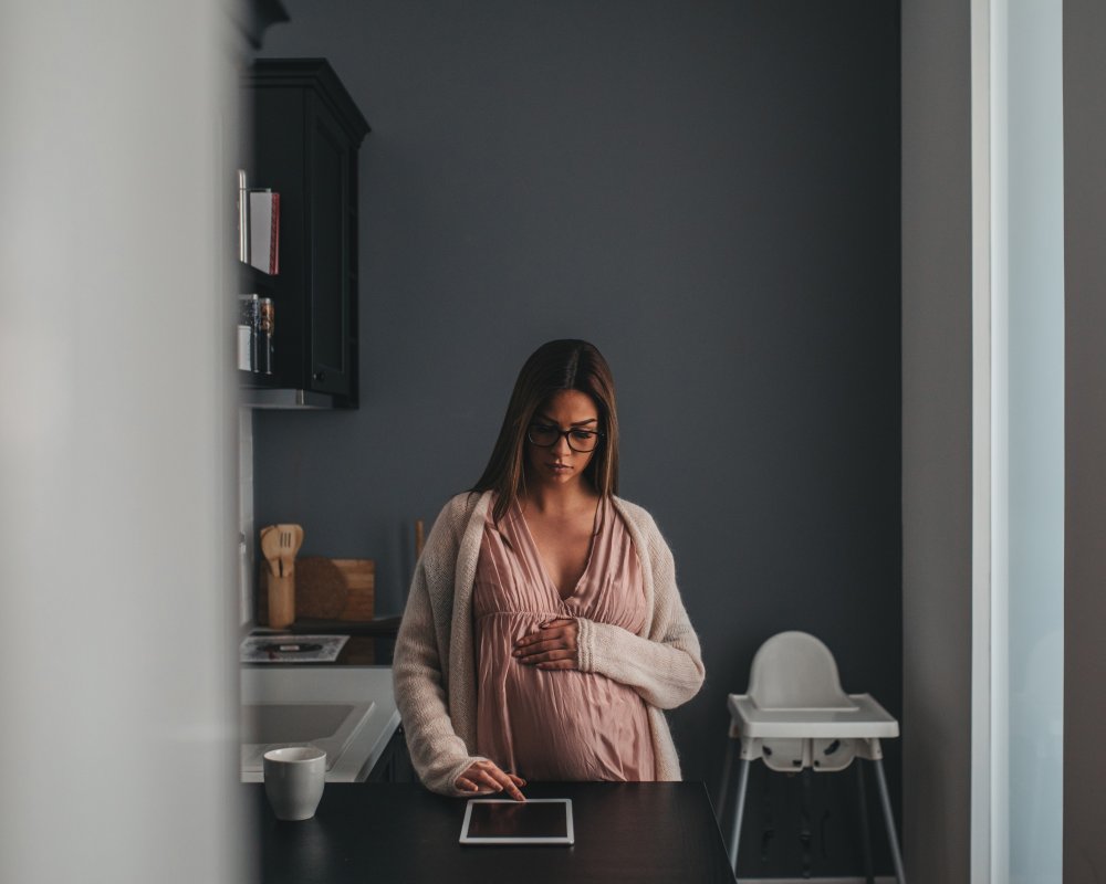 expecting-woman-checks-tablet-in-bright-home-2026-03-09-23-52-15-utc