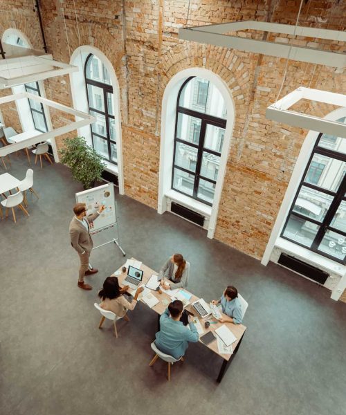 leader-standing-near-flipchart-and-pointing-at-gra-2026-01-08-22-03-35-utc